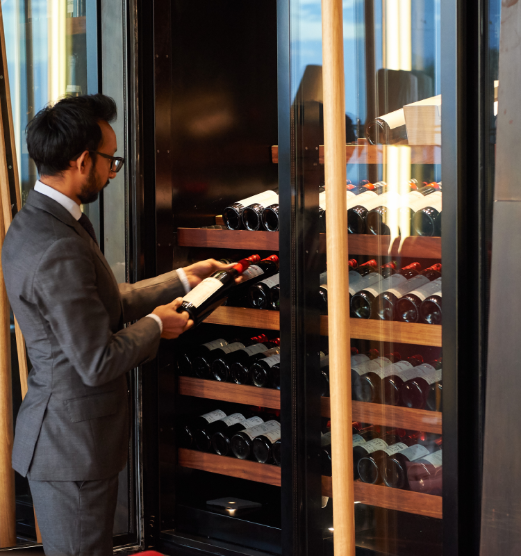Sommelier at Magill Estate Restaurant choosing a wine from the cellar
