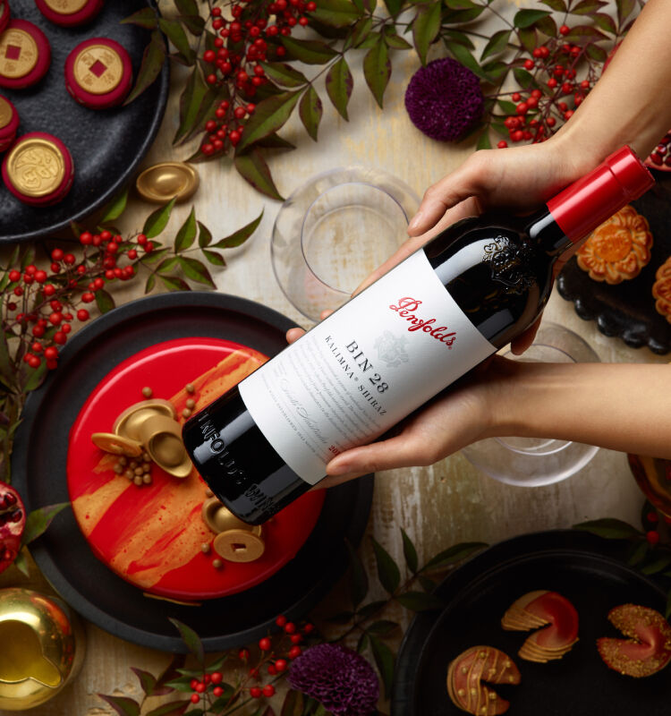 Penfolds Bin 28 held above festive table setting