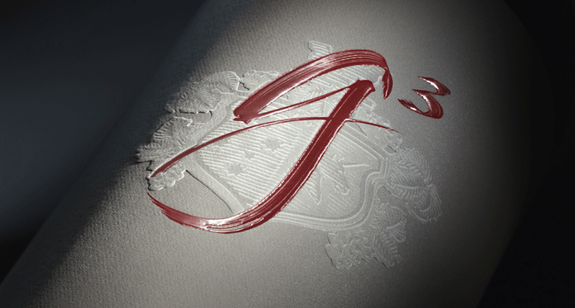 Close up of Penfolds g3 front label.  Red calligraphy script shows g ^ 3.  A embossed crest is visible behind. 