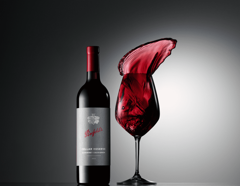 Cellar Reserve Cabernet with wine glass.  Wine dramatically leaps from the glass