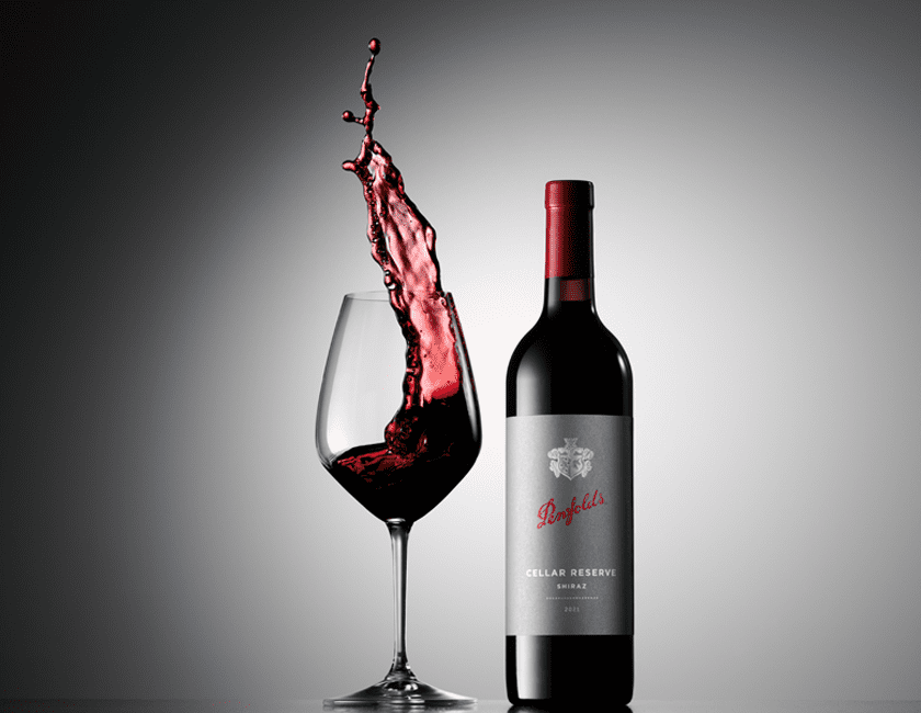 Cellar Reserve Shiraz with wine glass. Wine dramatically leaps from the glass