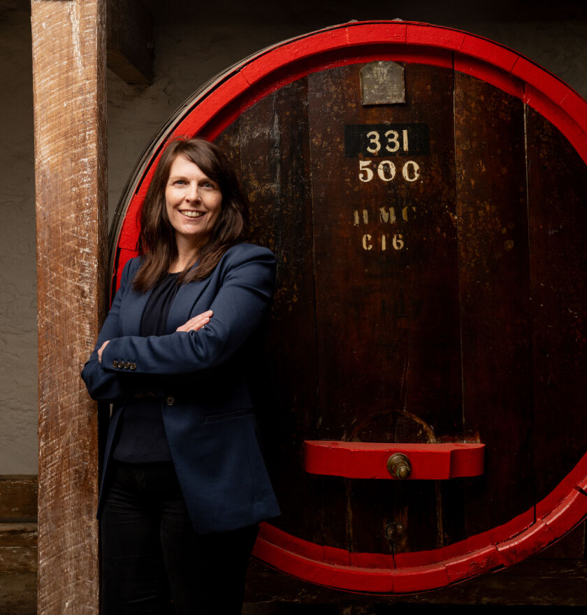 Shavaughn Wells, Penfolds Winemaker, in front of Penfolds barrel.